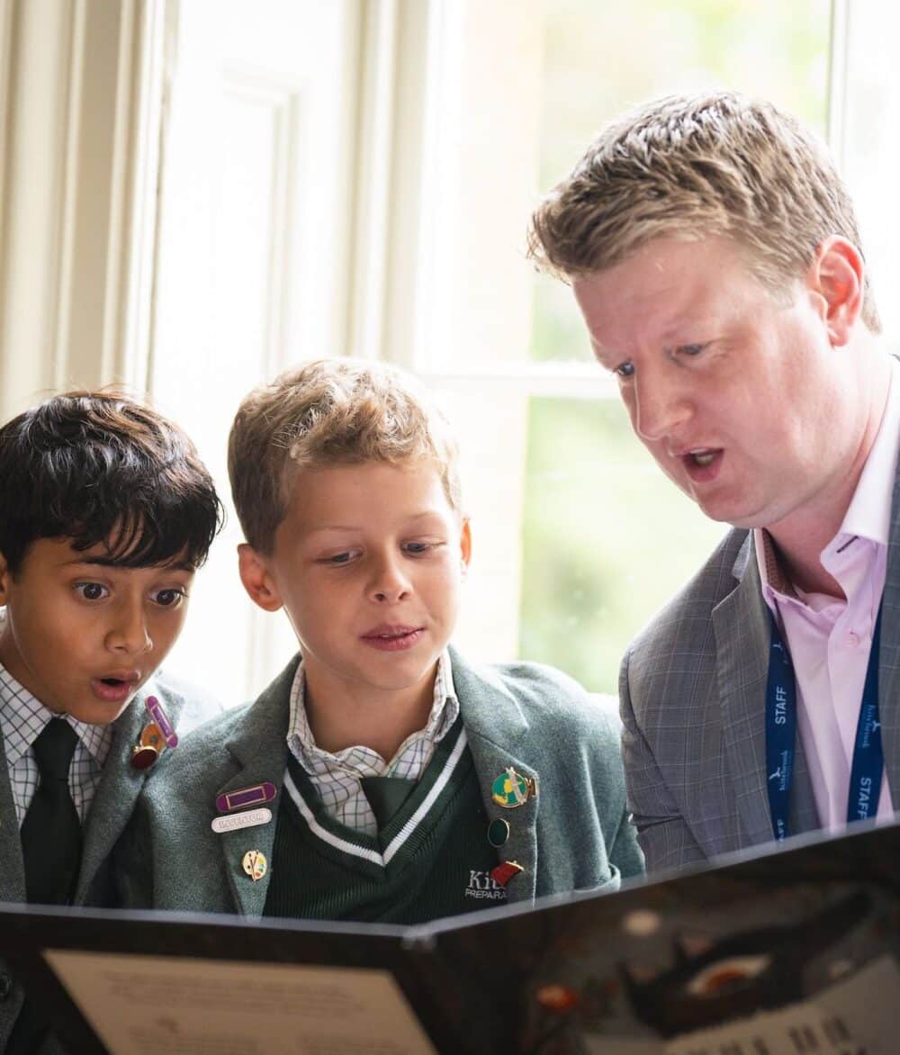 Teacher reading with two pupils